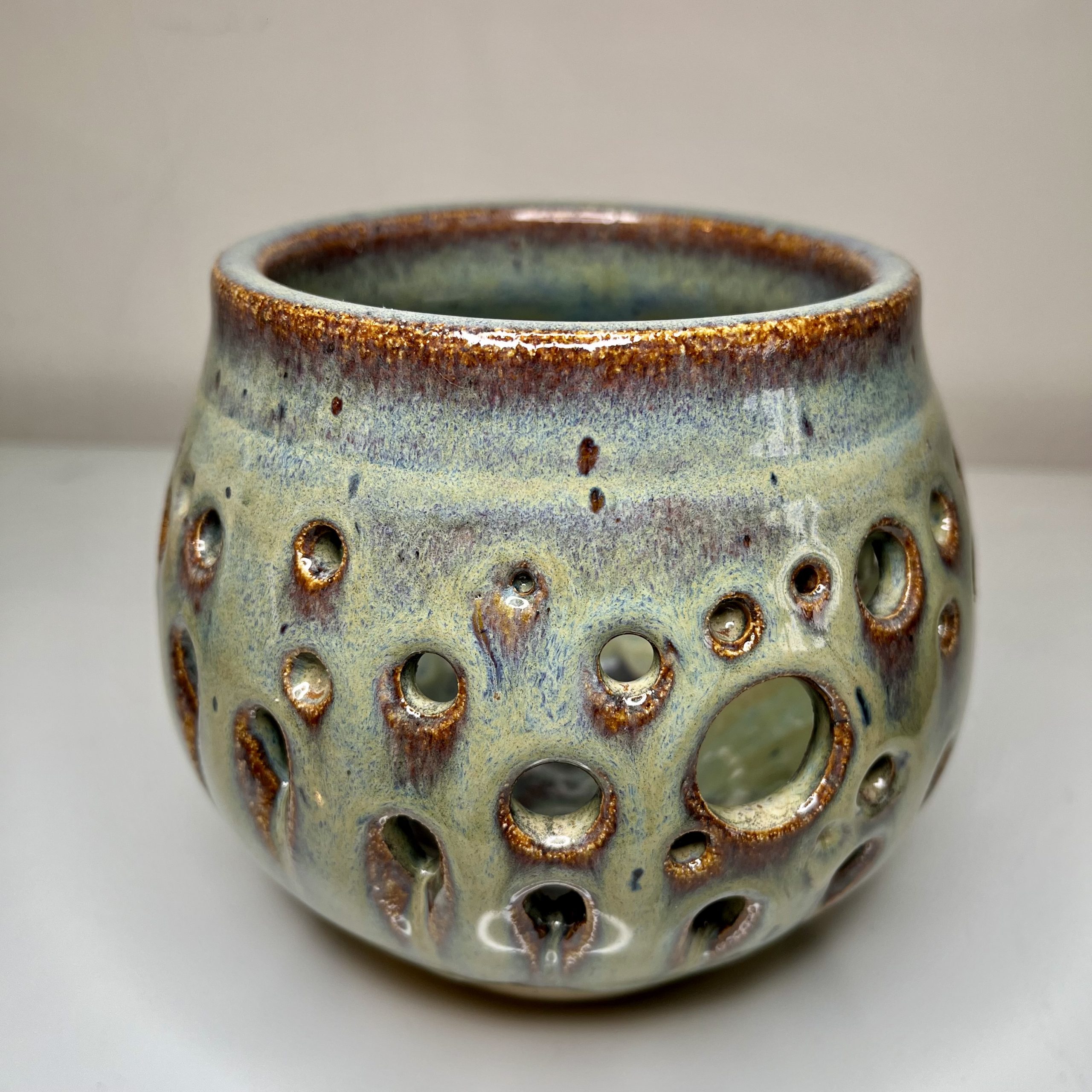 spherical hand thrown pot with hole for a tea light. Representing bubbles. Glossy Turquoise and brown