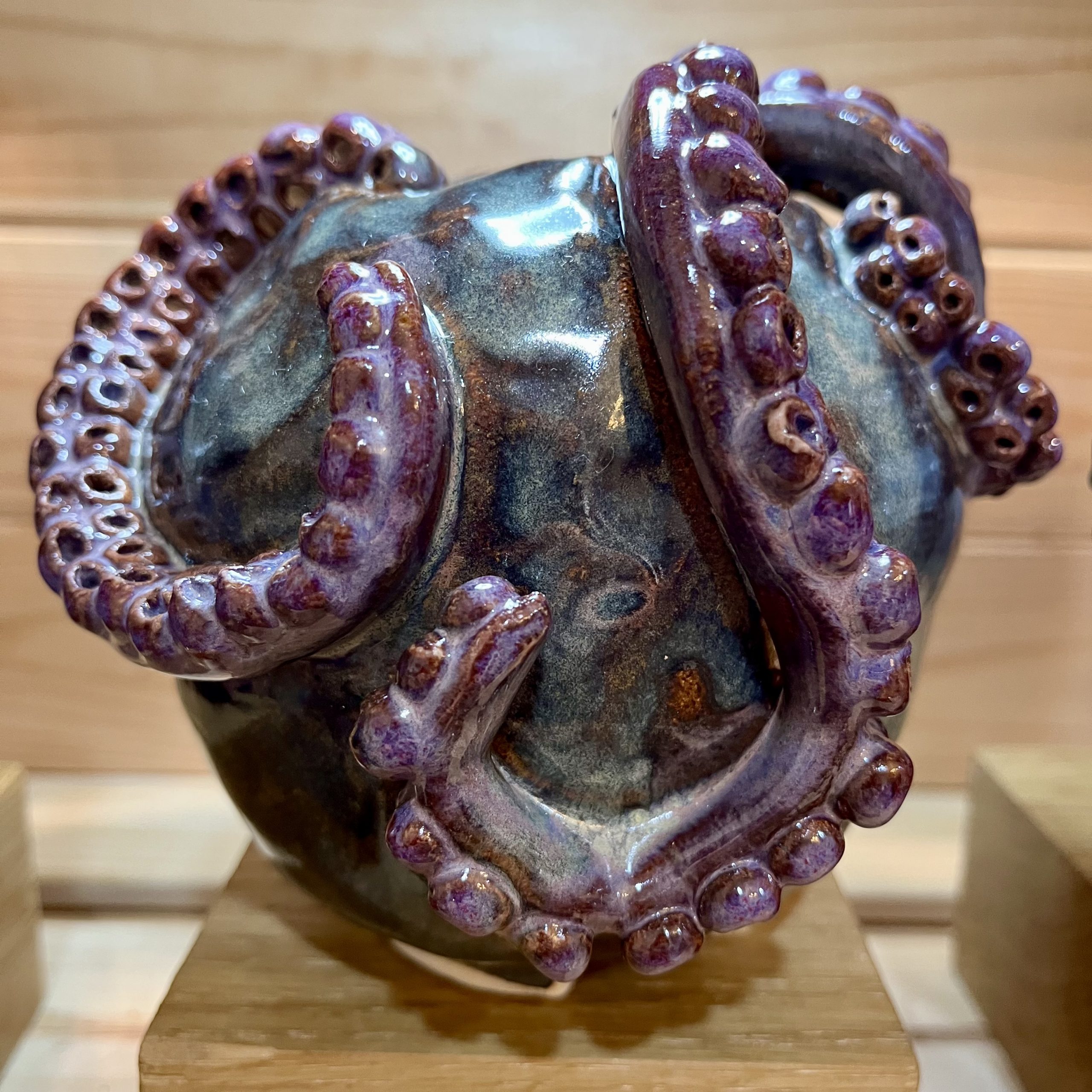 Blue pot with purple with tentacles coming out of the top