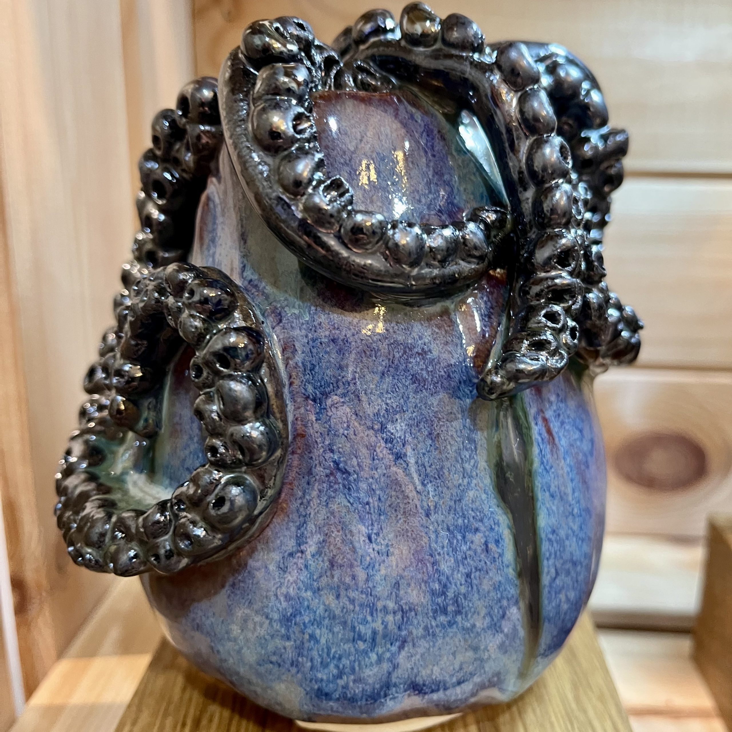 tall blue pot with black tentacles coming out of the top.